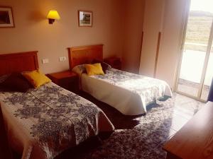 El CercadoHotel Sonia Chipude的酒店客房设有两张床和窗户。
