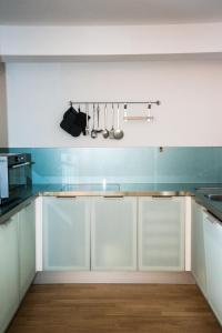 锡耶纳La casa in Camollia的厨房配有白色橱柜和蓝色的墙壁