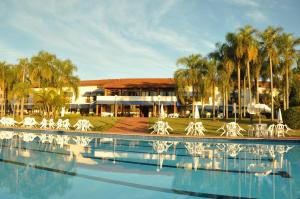 阿瓦雷Hotel Península的一座带白色椅子的游泳池和一座建筑