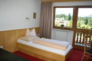 洛伊塔施高地酒店的一间卧室设有一张床和一个大窗户