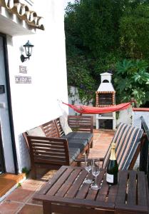 贝纳尔马德纳Casa Christabel y Casa Annabel的庭院里的木桌和一瓶葡萄酒