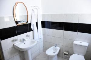 GramshHotel Latifi的一间带水槽、卫生间和镜子的浴室