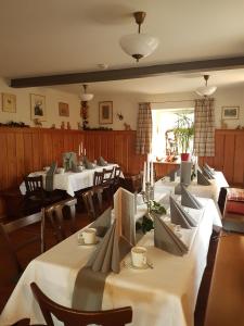诺德海姆市场Wirtshaus am Markt的用餐室配有桌椅和白色桌布