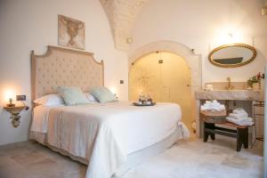 马丁纳弗兰卡Relais l’Antico Pozzo的一间卧室配有一张大床和镜子