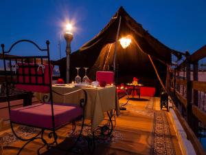 马拉喀什Riad Sérénis的帐篷在甲板上配有桌椅