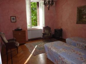 卡斯泰莱托索普拉蒂奇诺Casa Raffaello的一间卧室设有两张床、椅子和窗户