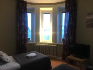 斯特伦松德Grand Hotell的卧室配有床、电视和窗户。