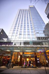 纽约Riu Plaza New York Times Square的一座高大的建筑,前面有人站在