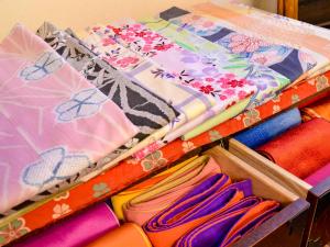 由布市Sanso Matsuya的抽屉里装满了不同的颜色的织物和雨伞