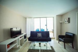 阿尔加罗沃San Alfonso Del Mar Apartment的客厅配有蓝色的沙发和电视