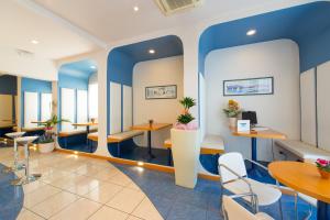 里乔内古丽塔酒店的一间拥有蓝色墙壁和桌椅的等候室