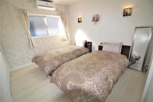 龙乡町Amami Mahalo的一间卧室设有两张床和窗户。