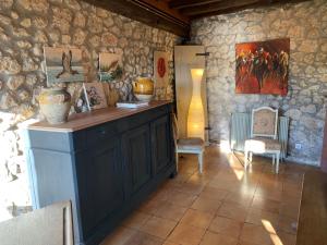 Le Tourneannexe du Mesnil的一间设有石墙、柜台和桌子的房间