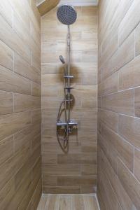 乌日策HOUSE OF SURPRISE的木制墙壁上带淋浴头的淋浴