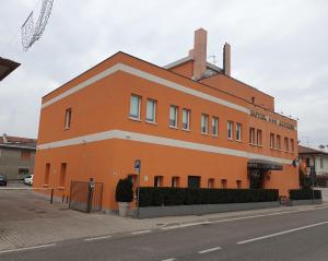 法瓦罗威尼托阿尔蒂里酒店的街道边的一座橙色大建筑