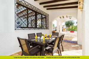莫莱拉Solhabitat Villa Oasis的一间用餐室,配有黑色的桌子和椅子