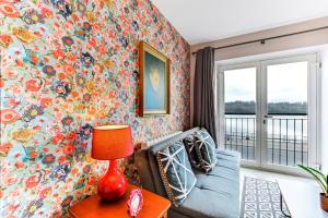 伦敦德里Riverside Apartment的客厅设有蓝色的沙发和花卉墙