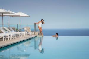 索列尔港美亚港索勒温泉酒店的站在游泳池边缘的女人
