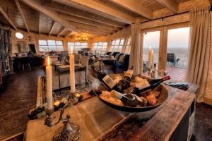 MöwebaaiShipwreck Lodge的一间房间,配有一张桌子和瓶装葡萄酒