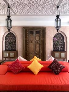 梅尔皮姆The Ryad Rayong的客房内的红色沙发,配有色彩缤纷的枕头