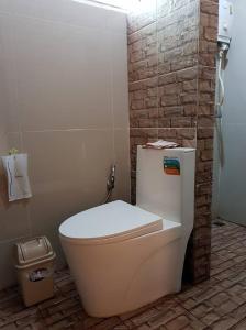 帕府罗麦塞萨恩度假酒店的浴室设有白色卫生间和砖墙