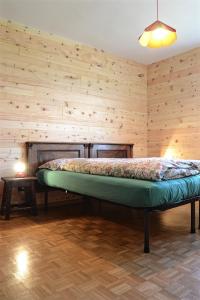 卡拉诺Casa del Salice的木墙客房的一张床位