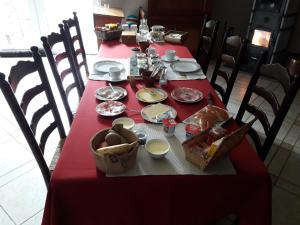 Haaltert穆森泽勒住宿加早餐旅馆的一张桌子,上面有红色的桌布,上面有食物