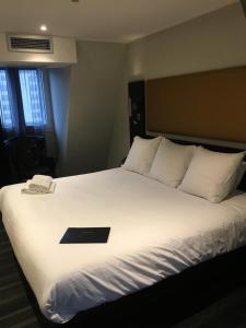 里昂Hôtel Boutique Richelieu, Lyon Gare Part-Dieu的上面有黑书的床