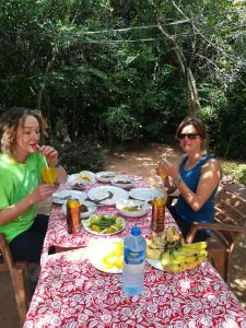 维勒珀图Hidden Jungle Village的两个坐在桌子边的女人,拿着食物和饮料