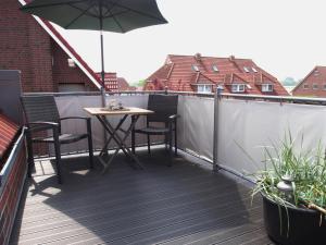 卡罗利嫩西尔An´t Möhlen的阳台配有桌椅和遮阳伞
