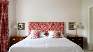弗朗斯胡克Laurel Cottage的一间卧室配有一张白色大床和红色床头板