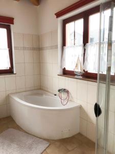 KröslinHaus am Meer的带窗户的浴室内的白色浴缸