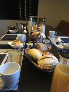 阿森"In de Kloosterhof" Gratis privé parkeren的桌子上摆放着一篮面包的桌子