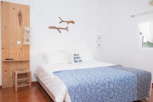 阿尔热祖尔Utopia的白色卧室配有一张带蓝色毯子的床