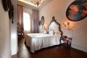 威尼斯麦唐娜大厦酒店的卧室配有一张床,墙上设有镜子