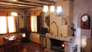 奥萨德蒙铁尔Casa Rural La Ossa的客厅设有壁炉、桌子和椅子