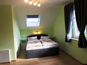 BodstedtHaus Kranichweide的一间位于绿色客房内的卧室,配有一张床