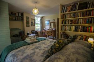 兰达西尔Penybanc Farm的卧室配有床和书架,书架上装满了书籍