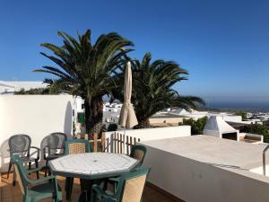 蒂亚斯Casa tranquila con vistas en la colina de tías的一个带桌椅和棕榈树的庭院
