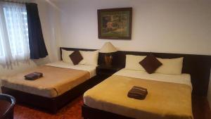 马尼拉马卡蒂吉瓦希酒店的酒店客房,设有两张床和一盏灯
