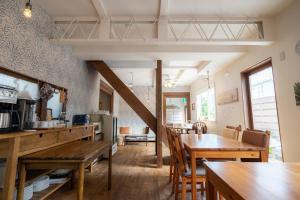 下田白滨海滨酒店的厨房以及带木桌和椅子的用餐室。