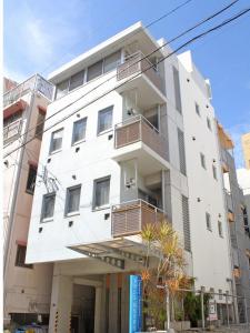 那霸Across Omoromachi Naha的白色的建筑,旁边设有阳台