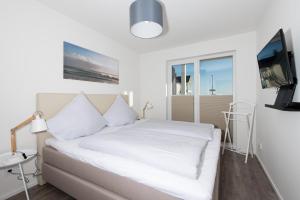 奥尔本尼兹Baltic Breeze的卧室配有白色的床和电视