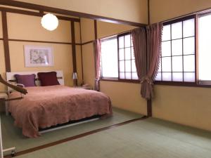 汤泽町Naeba Ski Resort - Cottage away from usual life的一间卧室设有一张床和两个窗户。