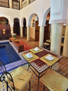 马拉喀什查理玛摩洛哥传统庭院住宅的配有桌椅和游泳池的客房
