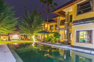 沙努尔沙努尔阿佩尔别墅酒店的一座晚上设有游泳池的房子