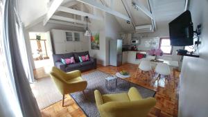 斯泰伦博斯Aan De Vliet Guest House的客厅配有沙发、椅子和桌子