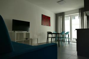 阿科Residenza Cinisca的客厅配有电视和桌椅