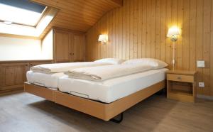 因特拉肯罗斯利假日公寓的一间带两张床铺的卧室,位于带木墙的房间内