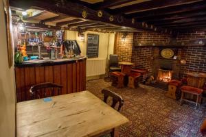 劳斯The Black Horse Inn的酒吧设有木桌和壁炉